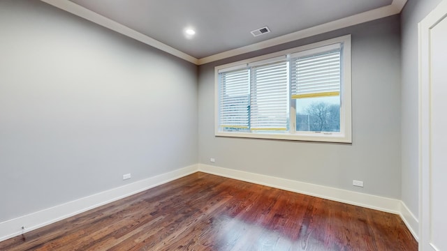 empty room featuring dark hardwood / wood-style flooring and ornamental molding