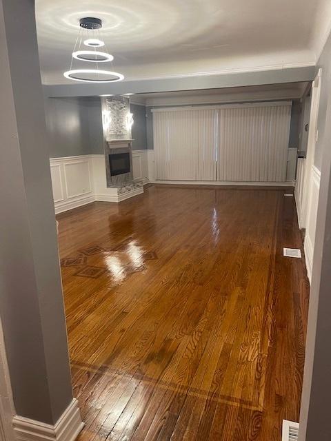 unfurnished living room featuring a fireplace and dark wood-type flooring