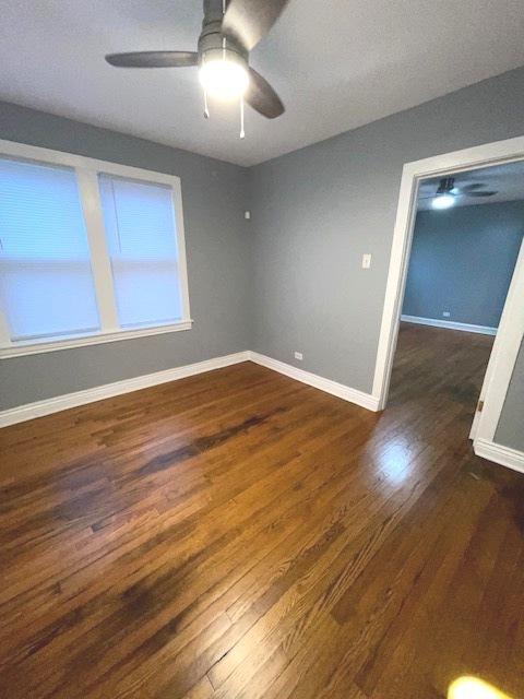 empty room with dark hardwood / wood-style floors and ceiling fan