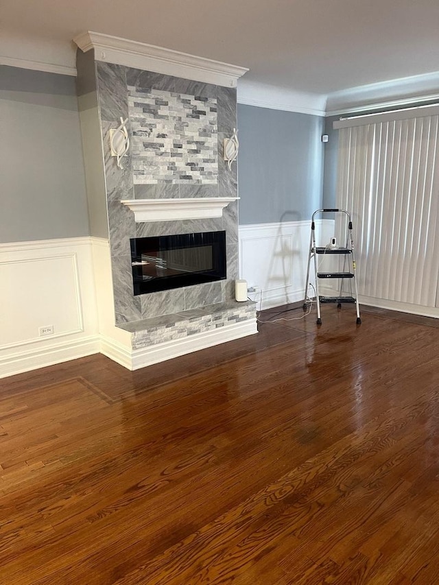 unfurnished living room featuring a fireplace, dark hardwood / wood-style floors, and ornamental molding