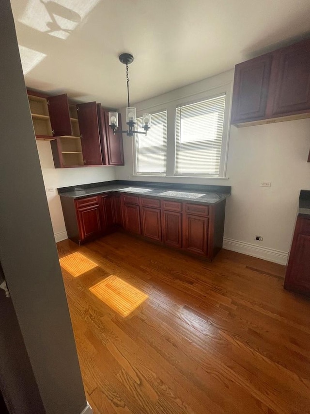 kitchen with dark wood-type flooring, decorative light fixtures, and a notable chandelier