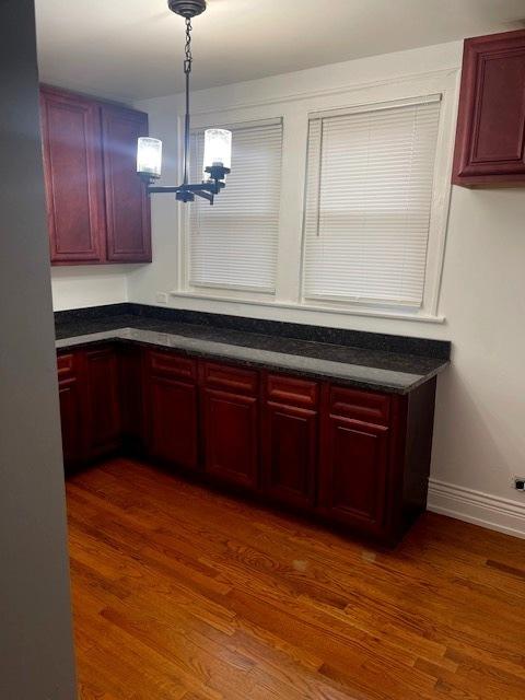 kitchen with pendant lighting, dark hardwood / wood-style flooring, and a notable chandelier