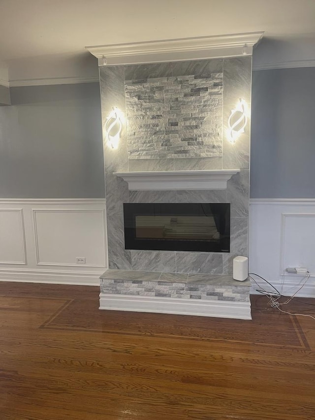 details featuring wood-type flooring, crown molding, and a tiled fireplace