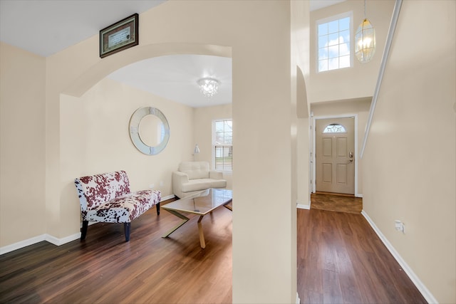 entryway with dark hardwood / wood-style floors and a notable chandelier