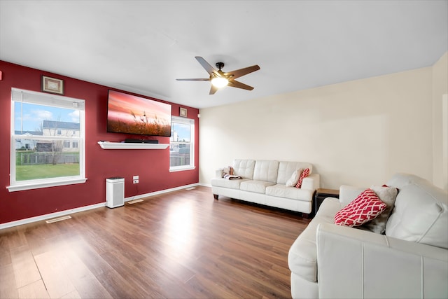 unfurnished living room with ceiling fan, plenty of natural light, and dark wood-type flooring