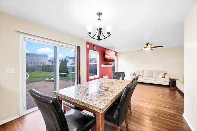 dining room with ceiling fan with notable chandelier and wood-type flooring