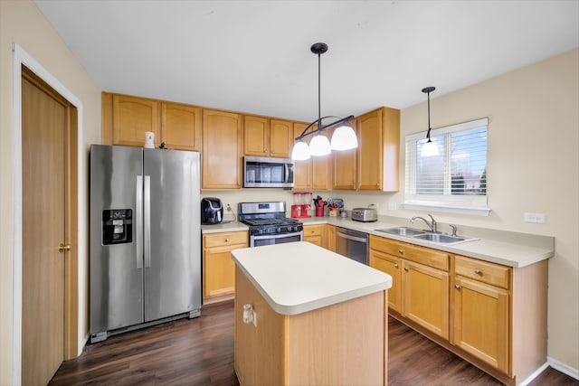 kitchen featuring a center island, sink, dark wood-type flooring, stainless steel appliances, and decorative light fixtures