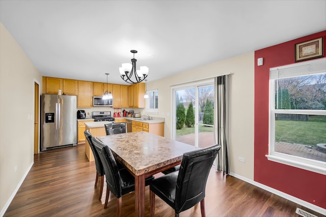 dining area featuring a chandelier, dark hardwood / wood-style floors, and sink