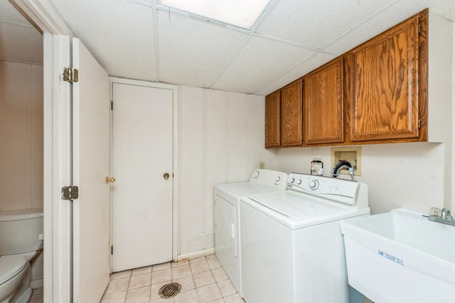 laundry room with light tile patterned flooring, cabinets, independent washer and dryer, and sink