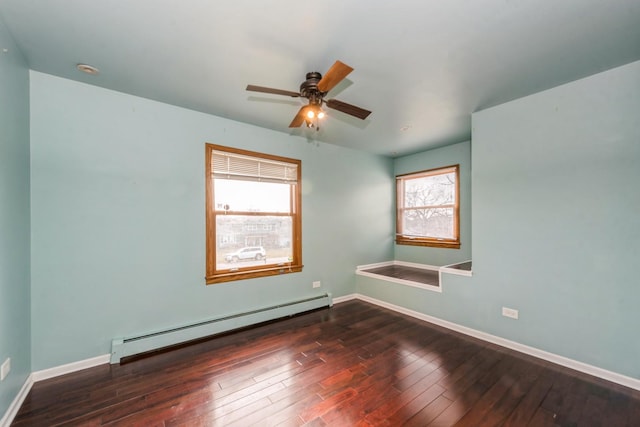 empty room with baseboard heating, ceiling fan, and dark hardwood / wood-style flooring