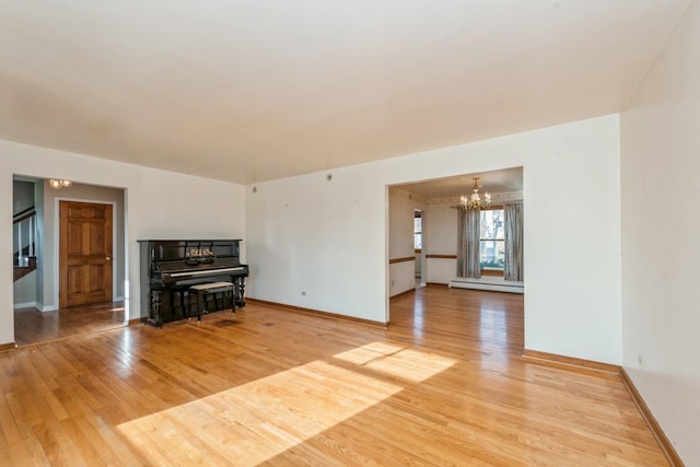 unfurnished living room featuring a chandelier, light wood-type flooring, and a baseboard radiator