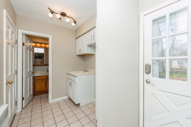 clothes washing area featuring sink and light tile patterned flooring