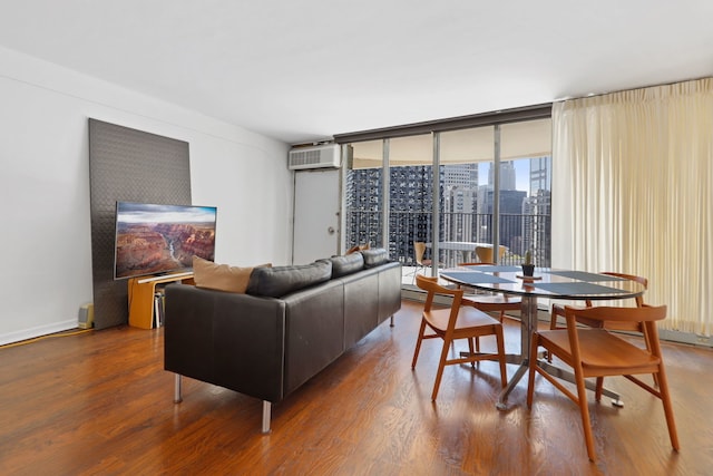 living room with floor to ceiling windows, wood-type flooring, and an AC wall unit