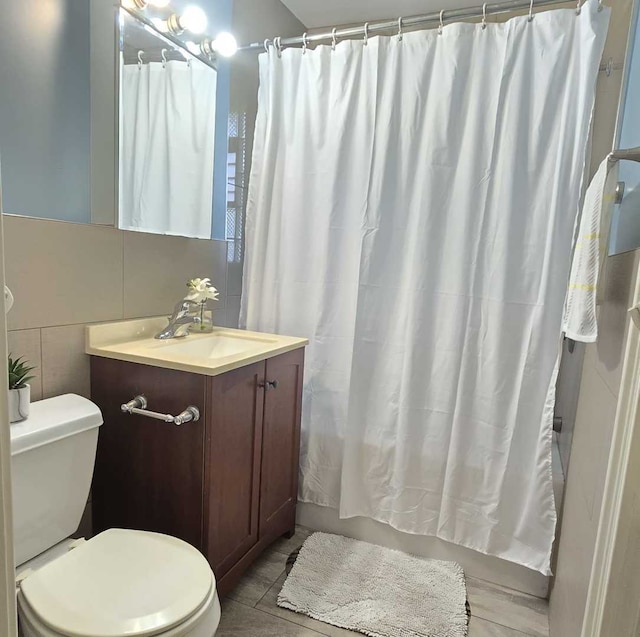 full bathroom featuring vanity, shower / bath combination with curtain, tile walls, and toilet