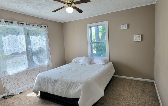 bedroom with carpet flooring, ceiling fan, ornamental molding, and a textured ceiling