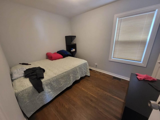 bedroom with dark wood-type flooring