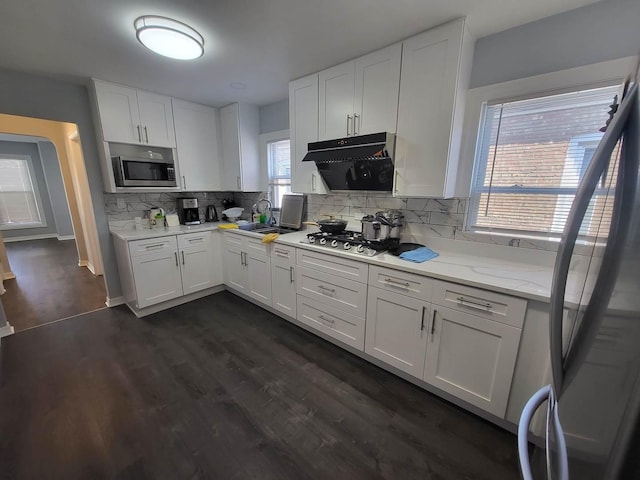 kitchen with white cabinets, stainless steel appliances, tasteful backsplash, and dark wood-type flooring