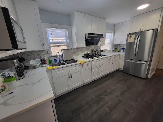 kitchen with white cabinets, decorative backsplash, stainless steel appliances, and dark hardwood / wood-style floors