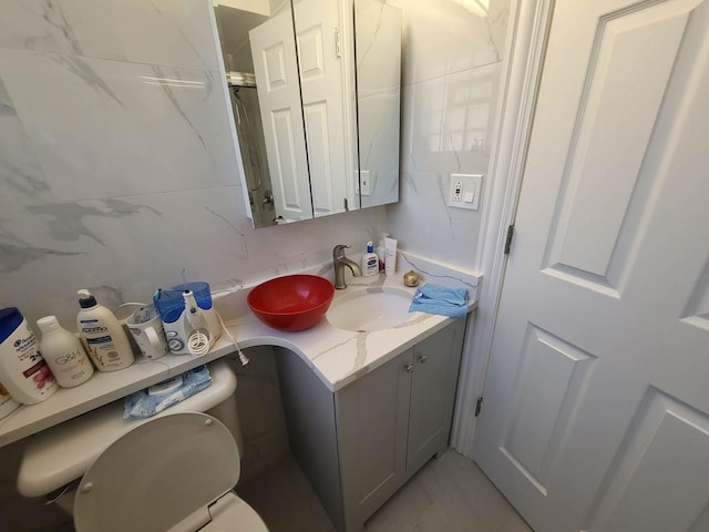 bathroom with vanity, toilet, and backsplash