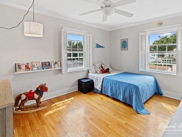 bedroom featuring hardwood / wood-style floors, ceiling fan, and ornamental molding