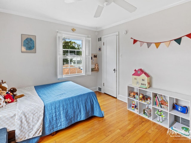 bedroom with hardwood / wood-style floors, ceiling fan, and crown molding