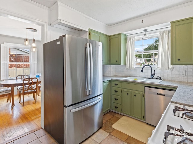 kitchen featuring sink, light wood-type flooring, green cabinetry, and appliances with stainless steel finishes