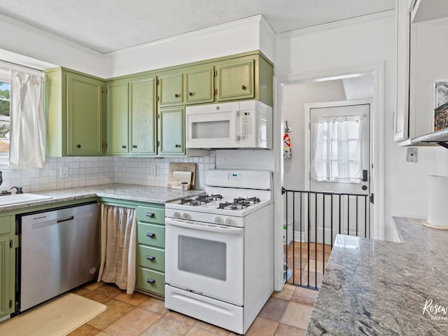 kitchen with backsplash, light stone counters, a textured ceiling, white appliances, and green cabinetry