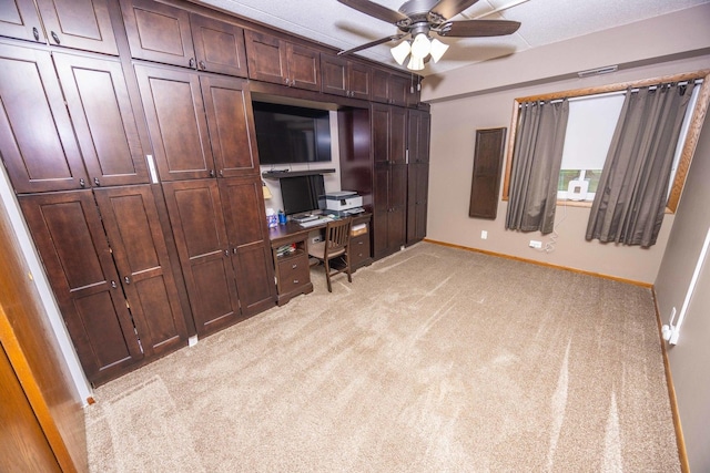 carpeted home office with ceiling fan and a textured ceiling