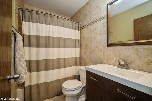 bathroom with vanity, tasteful backsplash, toilet, and tile walls