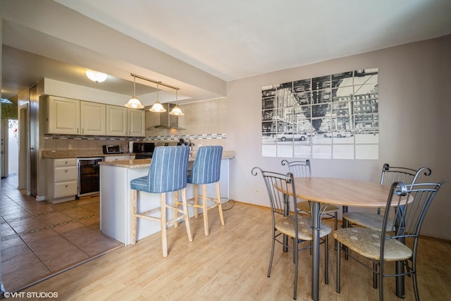 dining room featuring light hardwood / wood-style flooring and beverage cooler