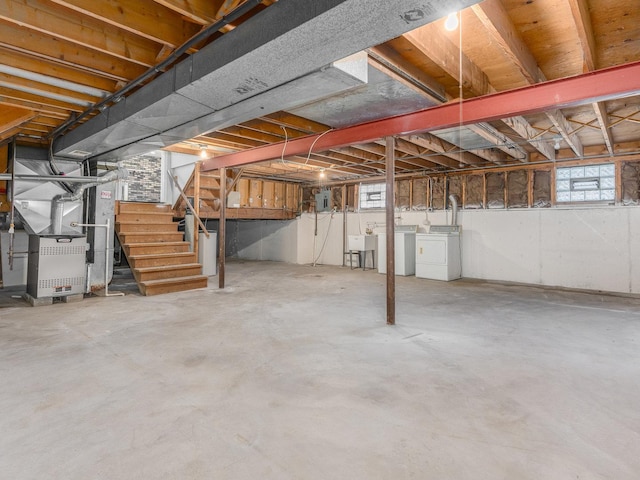 basement with washing machine and dryer, heating unit, and sink