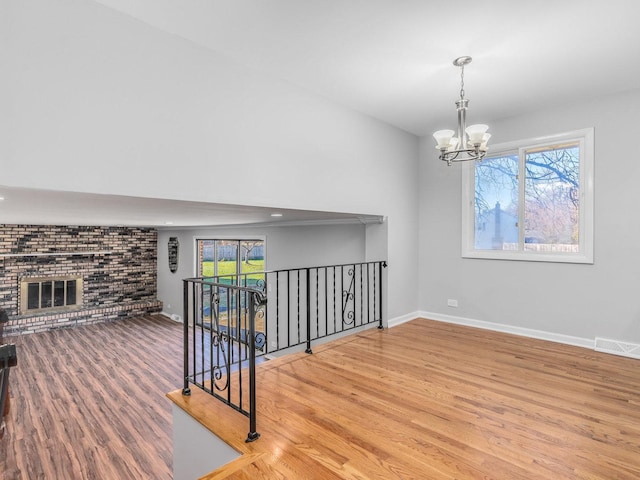 interior space with a fireplace, a chandelier, and hardwood / wood-style flooring