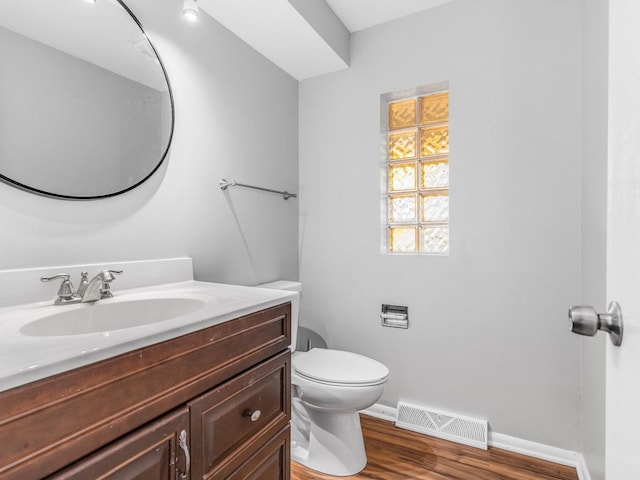 bathroom featuring toilet, vanity, and hardwood / wood-style flooring