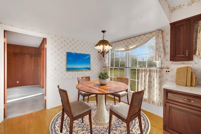 dining space with light hardwood / wood-style floors and a chandelier