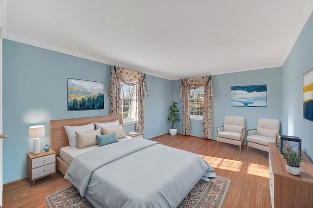 bedroom featuring light wood-type flooring and crown molding