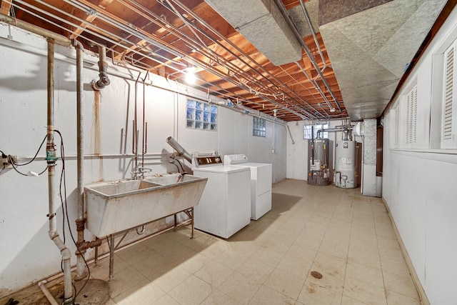 basement with sink, gas water heater, and washing machine and dryer