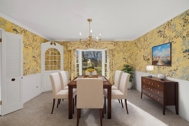 carpeted dining area with crown molding and a chandelier