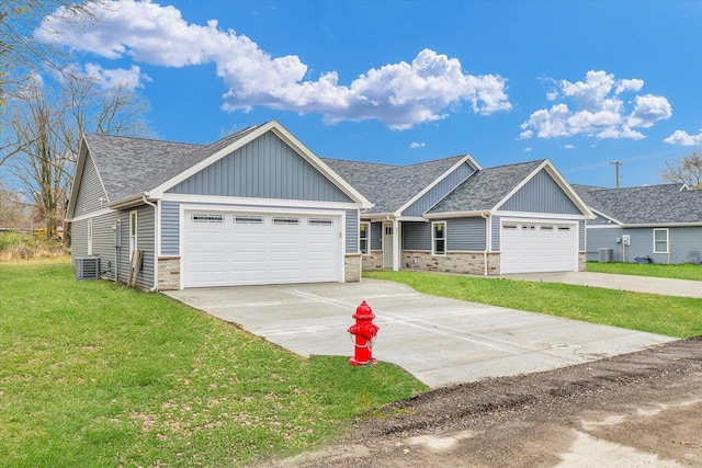 view of front of home featuring a garage, central AC unit, and a front yard