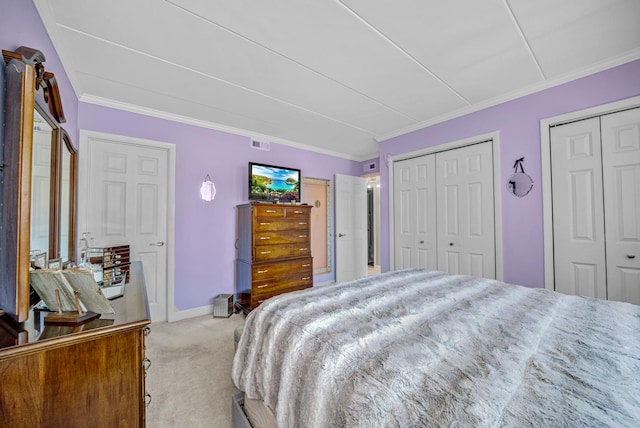 carpeted bedroom featuring two closets and crown molding