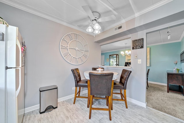 dining area featuring ceiling fan with notable chandelier, light hardwood / wood-style flooring, and ornamental molding