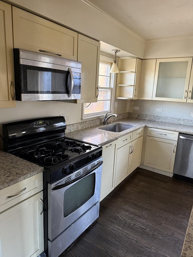 kitchen with dark hardwood / wood-style flooring, light stone counters, ornamental molding, stainless steel appliances, and sink