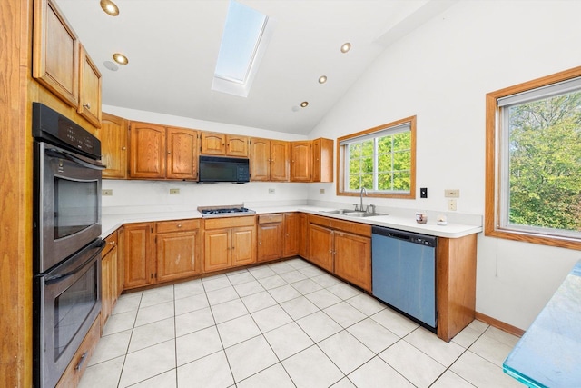 kitchen featuring a skylight, sink, light tile patterned flooring, and black appliances