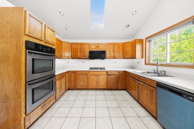 kitchen with sink, lofted ceiling with skylight, stainless steel appliances, and light tile patterned floors