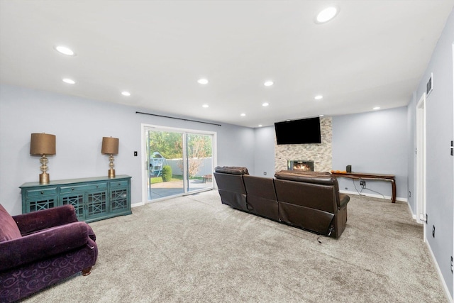 living room featuring a stone fireplace and light carpet