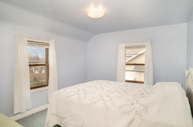 bedroom featuring light colored carpet and vaulted ceiling