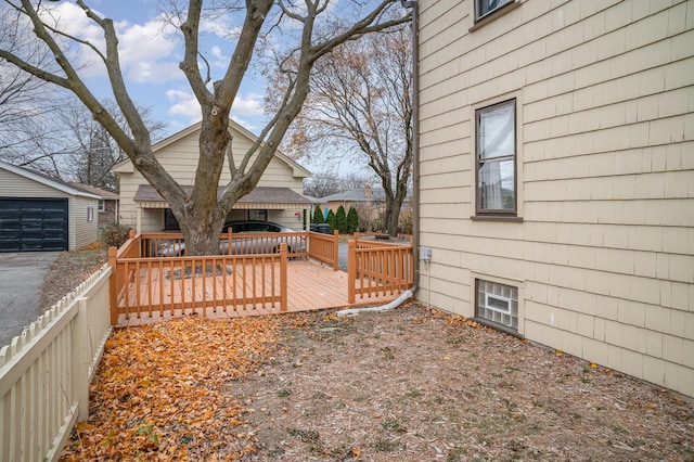 view of yard with a deck, a garage, and an outdoor structure