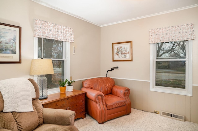 living area with wood walls, crown molding, and light carpet