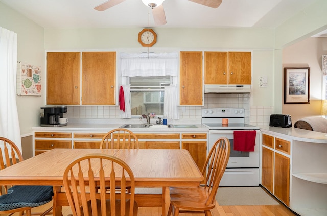 kitchen with decorative backsplash, light wood-type flooring, electric range oven, and sink