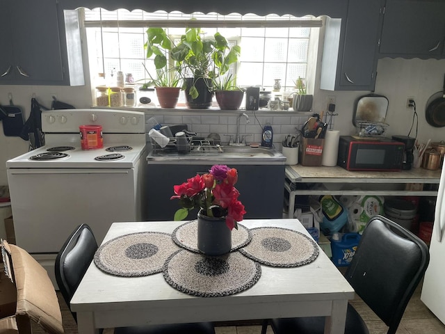 kitchen with gray cabinets, plenty of natural light, and electric stove