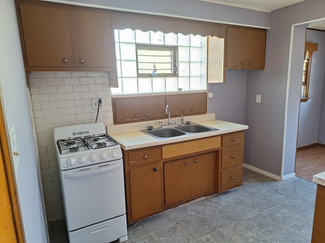 kitchen featuring white gas range oven and sink